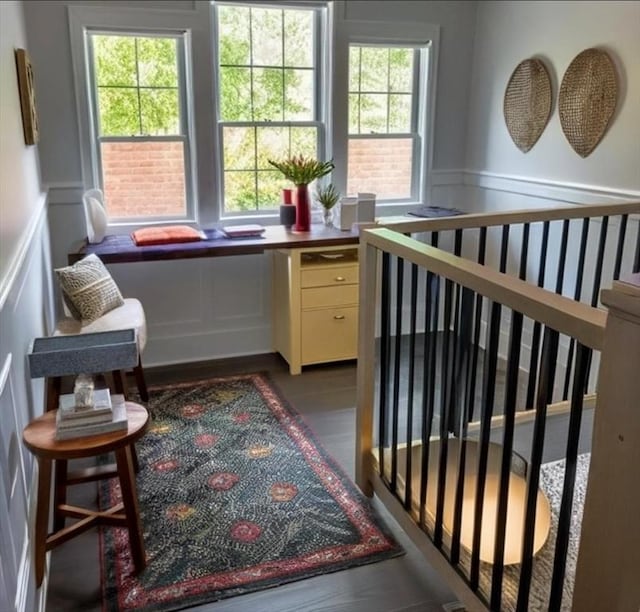 living area featuring built in desk, plenty of natural light, and dark wood-type flooring