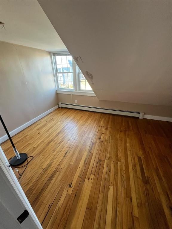 bonus room featuring hardwood / wood-style flooring and a baseboard heating unit