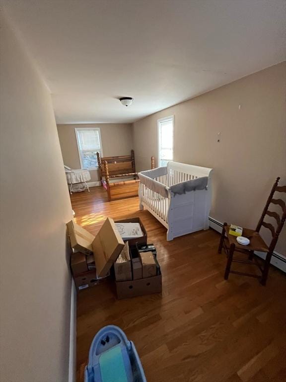 bedroom featuring a crib and dark wood-type flooring