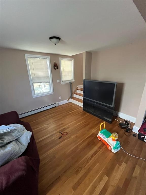 living room with baseboard heating and hardwood / wood-style floors