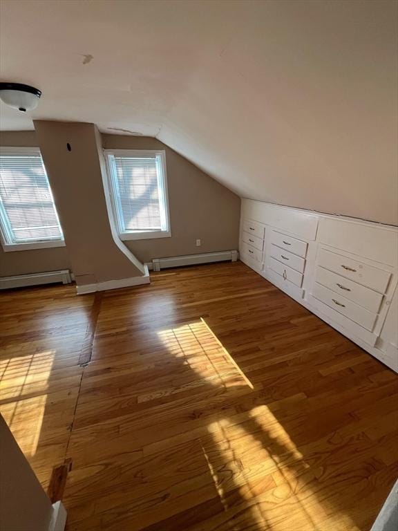 bonus room with hardwood / wood-style floors, lofted ceiling, and a baseboard heating unit