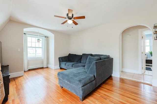 30 Crystal Cove Ave Unit 2, Winthrop, MA 02152 - living area featuring arched walkways, baseboard heating, light wood-style flooring, a ceiling fan, and plenty of natural light