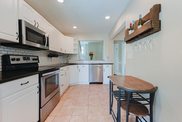 30 Crystal Cove Ave Unit 2, Winthrop, MA 02152 - kitchen with stainless steel appliances, open shelves, a sink, dark countertops, and decorative backsplash
