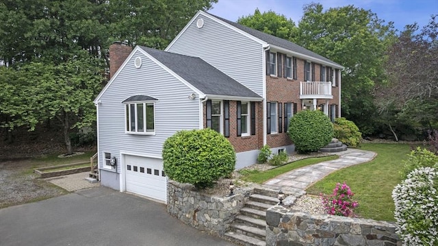 5 Ledgewood Rd, Saugus, MA 01906 - view of front of house with a chimney, driveway, an attached garage, brick siding, and a balcony