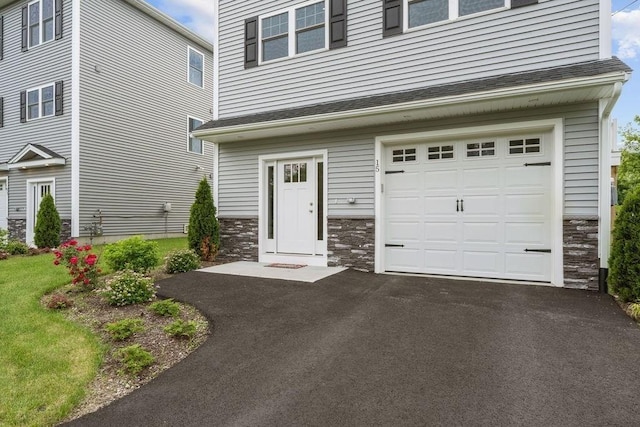 15 Spadina, Warwick, RI 02889 - view of front of home featuring stone siding, a garage, and driveway