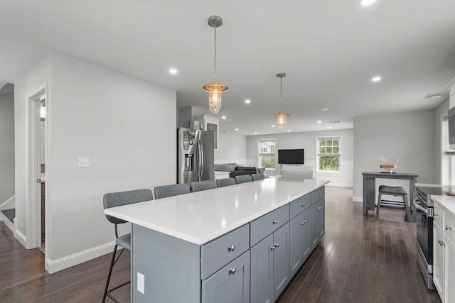 15 Spadina, Warwick, RI 02889 - kitchen with appliances with stainless steel finishes, a breakfast bar, a kitchen island, dark wood-style flooring, and recessed lighting