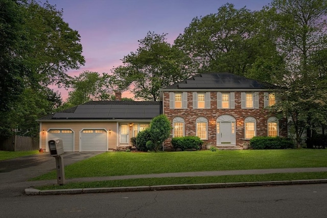 58 Berkeley Rd, North Andover, MA 01845 - colonial house featuring roof mounted solar panels, driveway, a lawn, an attached garage, and a chimney