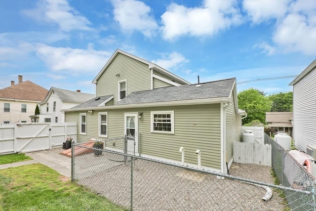 4063 Main St, Palmer, MA 01069 - rear view of property featuring a gate, a shingled roof, a fenced backyard, and a patio