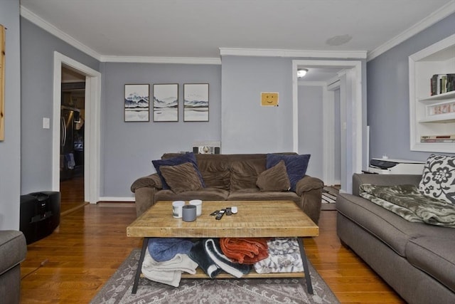 living room with baseboards, crown molding, and wood finished floors