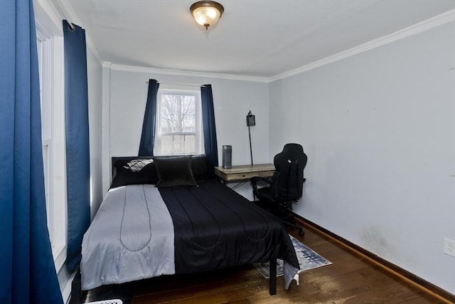 bedroom with baseboards, wood finished floors, and crown molding
