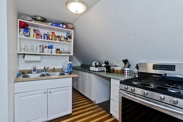 kitchen featuring vaulted ceiling, a sink, open shelves, stainless steel gas range oven, and white cabinets