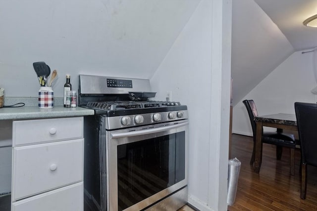 kitchen featuring white cabinets, stainless steel gas stove, lofted ceiling, and wood finished floors