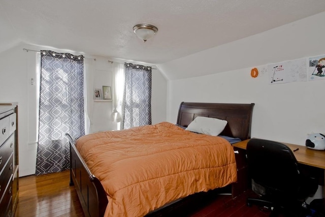 bedroom featuring dark wood-style flooring and lofted ceiling