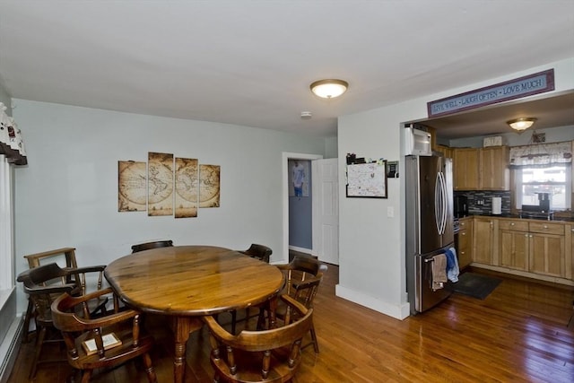 dining room featuring dark wood-type flooring and baseboards