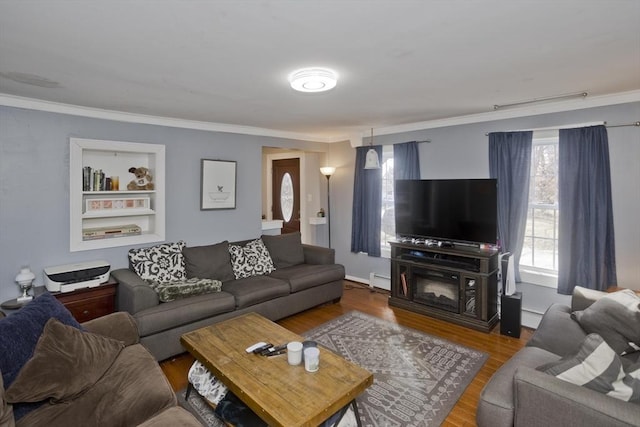 living area with a baseboard radiator, ornamental molding, built in features, and wood finished floors