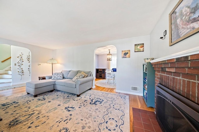 40 Mamie Rd, Weymouth, MA 02190 - living room with arched walkways, stairway, wood finished floors, and a brick fireplace