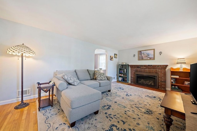 40 Mamie Rd, Weymouth, MA 02190 - living area featuring arched walkways, wood finished floors, baseboards, and a brick fireplace