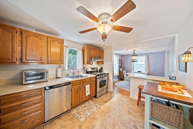 40 Mamie Rd, Weymouth, MA 02190 - kitchen with appliances with stainless steel finishes, under cabinet range hood, a sink, brown cabinets, and light countertops