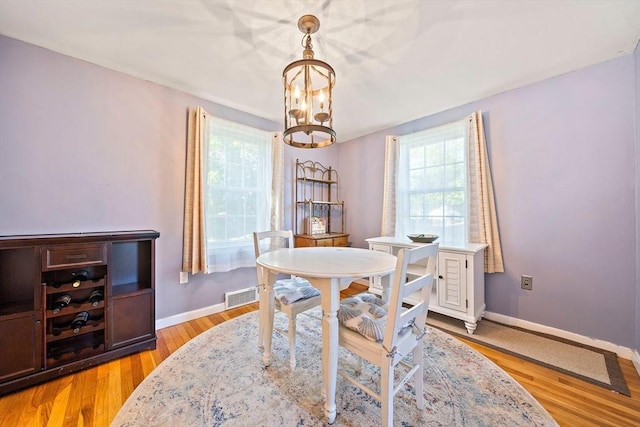 40 Mamie Rd, Weymouth, MA 02190 - dining room featuring a chandelier, baseboards, and light wood-style floors