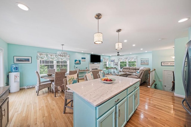 61 Hingham Ave, Marshfield, MA 02050 - kitchen with light wood-type flooring, decorative light fixtures, a center island, light stone countertops, and recessed lighting