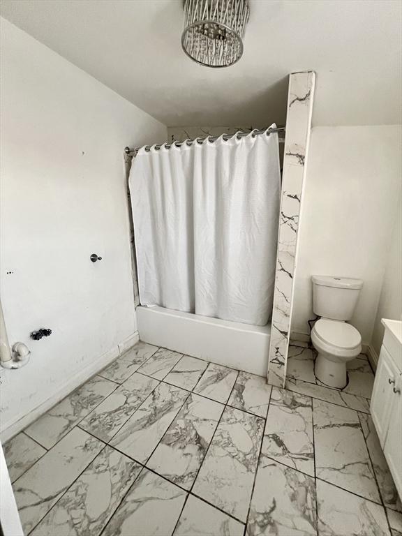 full bath with toilet, marble finish floor, baseboards, and vanity