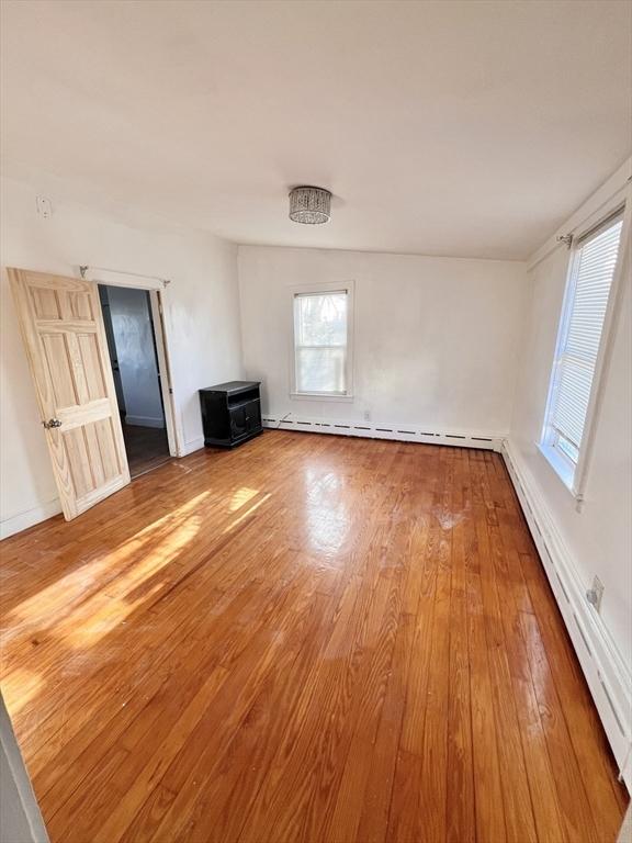 spare room featuring a baseboard radiator, a baseboard heating unit, and wood finished floors