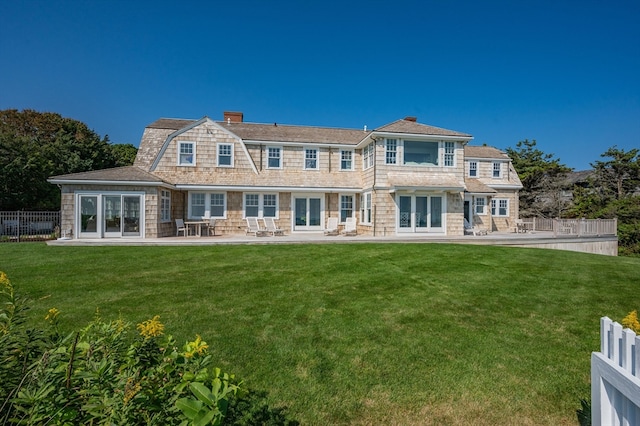 back of property featuring a patio and a yard