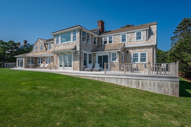 back of house with a deck and a lawn