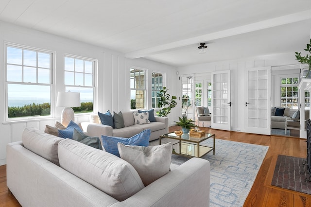 living room with wood-type flooring, beam ceiling, and french doors