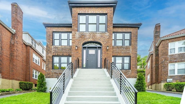 140 Columbia St, Brookline, MA 02446 - view of front facade with brick siding and a front lawn
