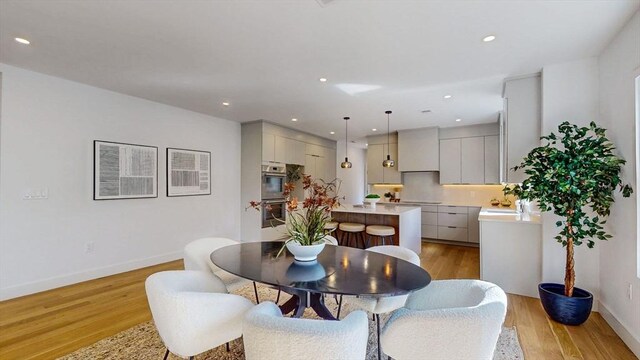 140 Columbia St, Brookline, MA 02446 - dining space with light wood finished floors, baseboards, and recessed lighting