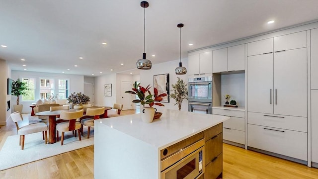 140 Columbia St, Brookline, MA 02446 - kitchen with appliances with stainless steel finishes, light wood finished floors, modern cabinets, white cabinets, and recessed lighting