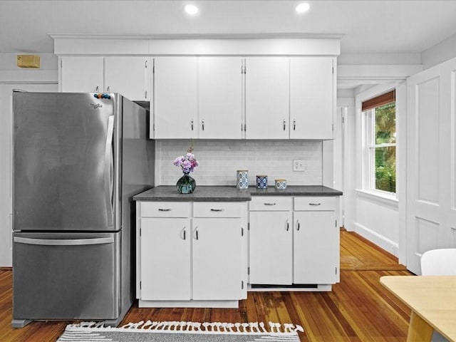 kitchen with freestanding refrigerator, dark countertops, dark wood-style floors, tasteful backsplash, and recessed lighting