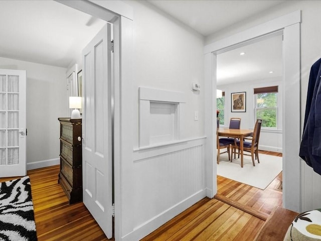 corridor with hardwood / wood-style flooring and baseboards