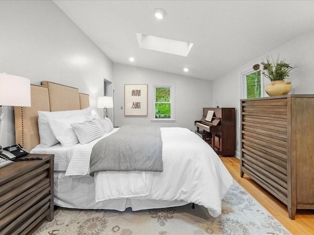bedroom with a skylight, vaulted ceiling, light wood-type flooring, and recessed lighting