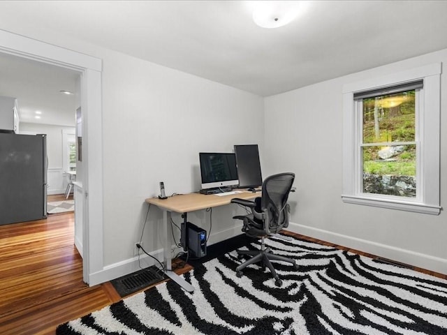office space with wood finished floors, baseboards, and plenty of natural light