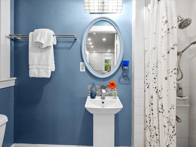 bathroom with a tile shower and toilet