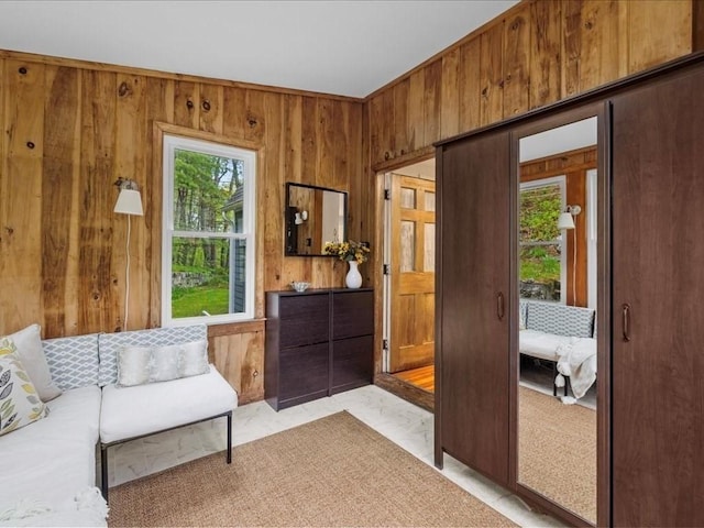 living area with wood walls and light marble finish flooring