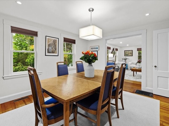 dining area featuring healthy amount of natural light, baseboards, wood finished floors, and recessed lighting