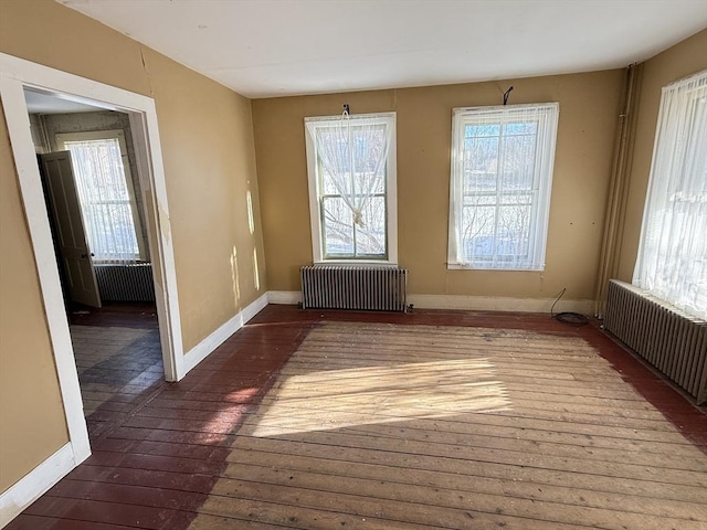 spare room featuring a healthy amount of sunlight and radiator