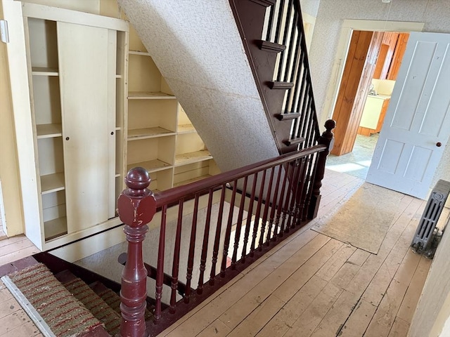 staircase with hardwood / wood-style flooring, vaulted ceiling, and washer / dryer