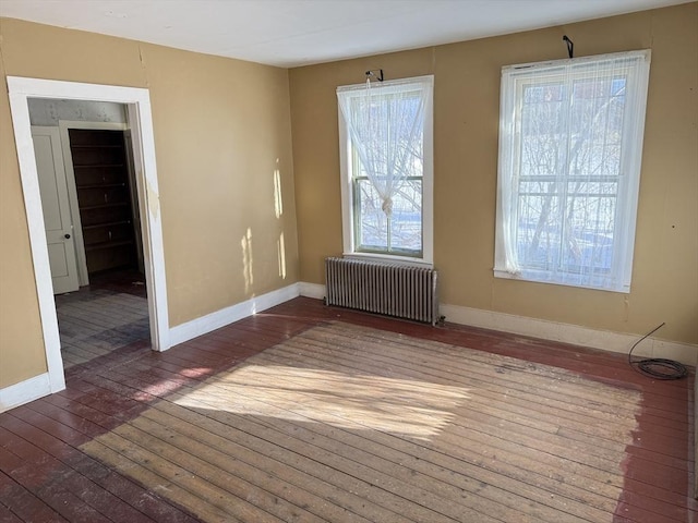 empty room featuring radiator and dark wood-type flooring