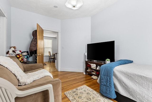 bedroom with light wood-style flooring and baseboards