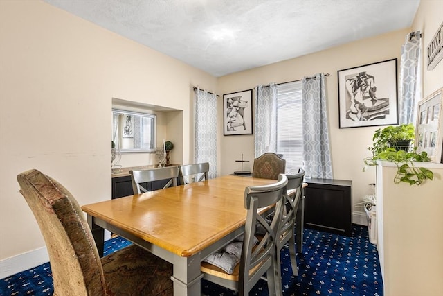 dining room with baseboards and dark colored carpet