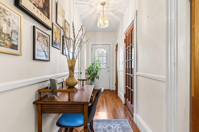 office area featuring a chandelier, wood finished floors, and baseboards