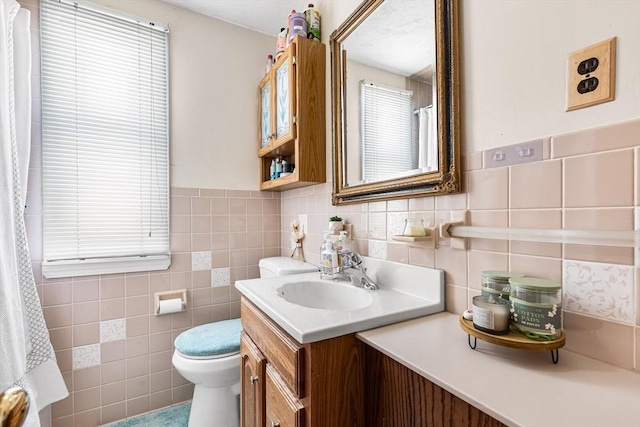 bathroom with vanity, tile walls, and toilet