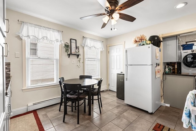 tiled dining area featuring washer / dryer, a baseboard radiator, plenty of natural light, and ceiling fan