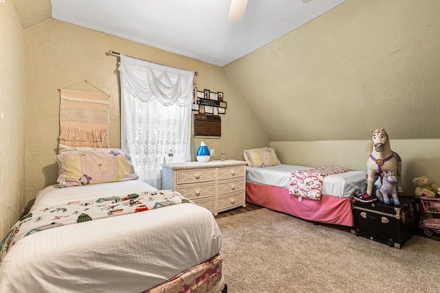 carpeted bedroom with lofted ceiling, ceiling fan, and a textured wall