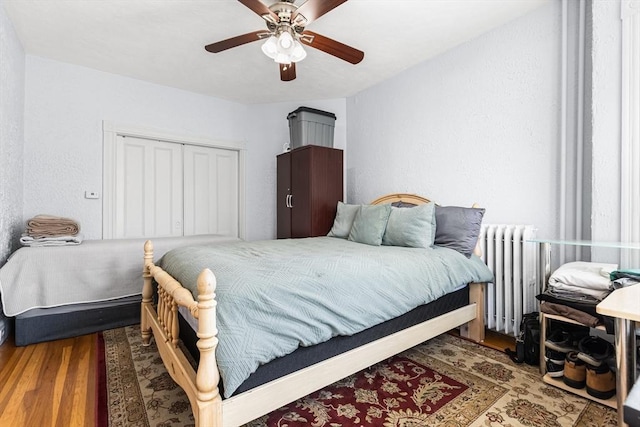 bedroom featuring radiator heating unit, wood finished floors, and ceiling fan