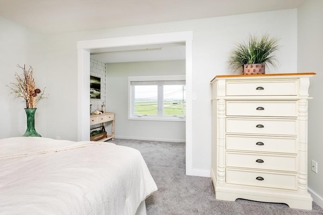 bedroom featuring light carpet and baseboards
